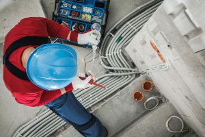 Electrician checking wires of a light fixture.